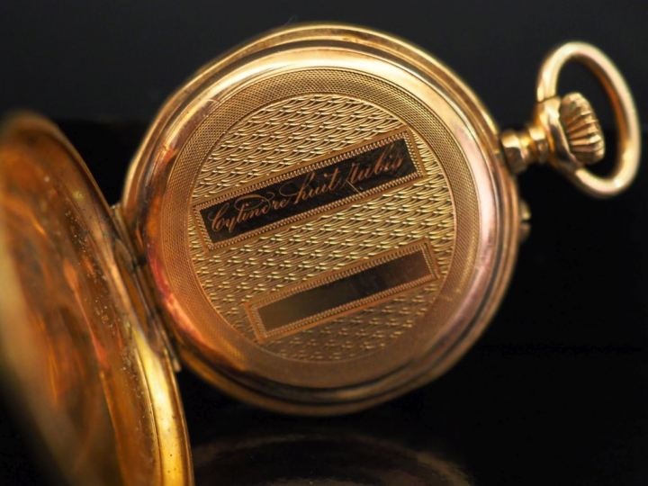 Montre de col en or jaune.  Cadran à chiffres romains pour les heures 