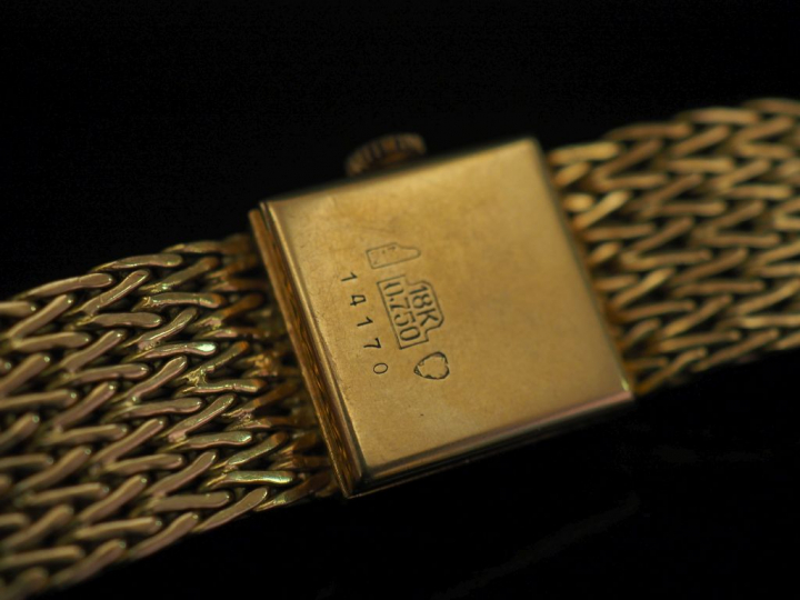 Montre bracelet, boitier et bracelet en or jaune.  Cadran carré à moti