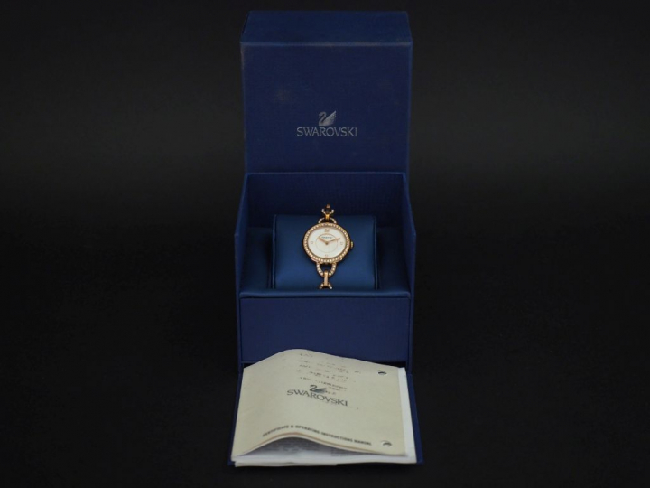 SWAROVSKI Montre bracelet de dame en métal doré, rehaussé sur le cadra