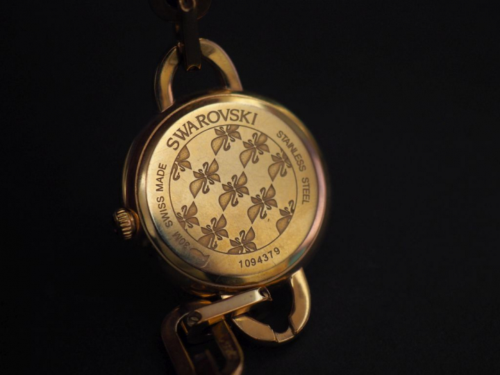 SWAROVSKI Montre bracelet de dame en métal doré, rehaussé sur le cadra