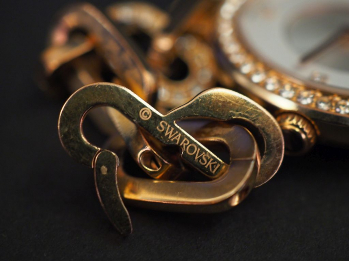 SWAROVSKI Montre bracelet de dame en métal doré, rehaussé sur le cadra