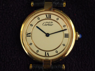 Vente aux enchères CARTIER, Must Montre bracelet en vermeil.  Cadran rond à chiffres roma