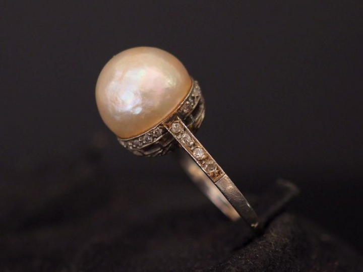Bague en platine, sertie en son centre d'une perle retenue par une bas