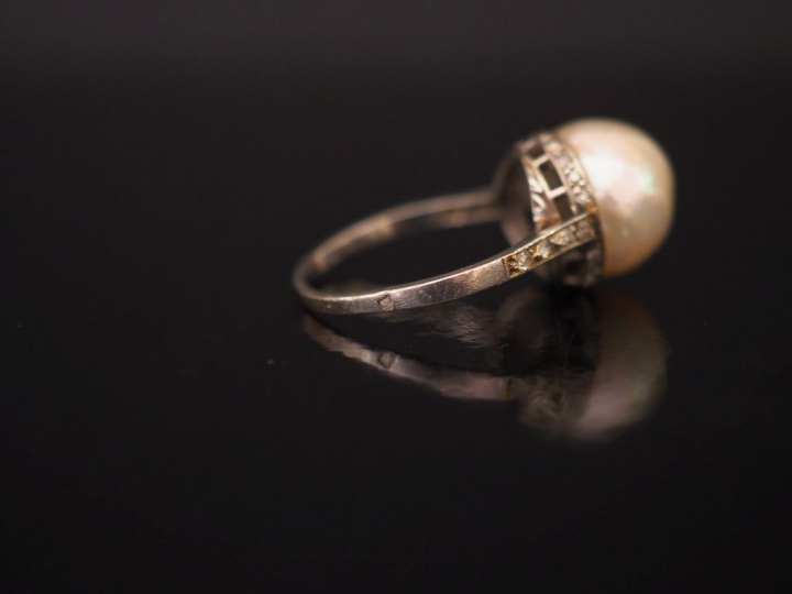 Bague en platine, sertie en son centre d'une perle retenue par une bas