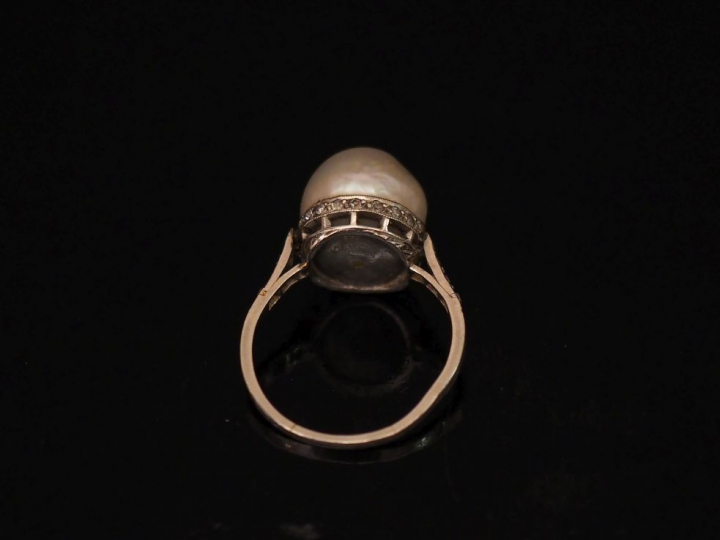 Bague en platine, sertie en son centre d'une perle retenue par une bas