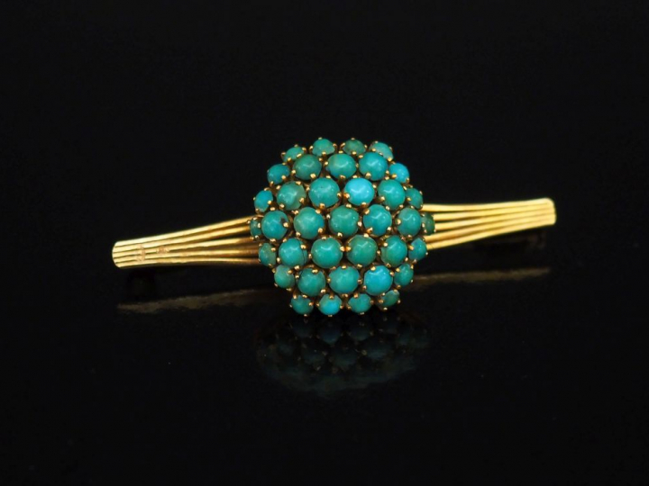 Broche de forme barrette, à décor en son centre d'un dôme serti de pet