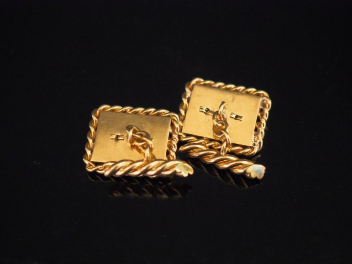 Paire de boutons de manchettes en or jaune et onyx noir, à décor de mo