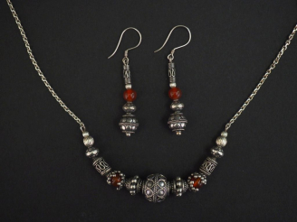 Vente aux enchères Demi-parure en argent et pierre rouge orangé. Comprenant :  - un colli