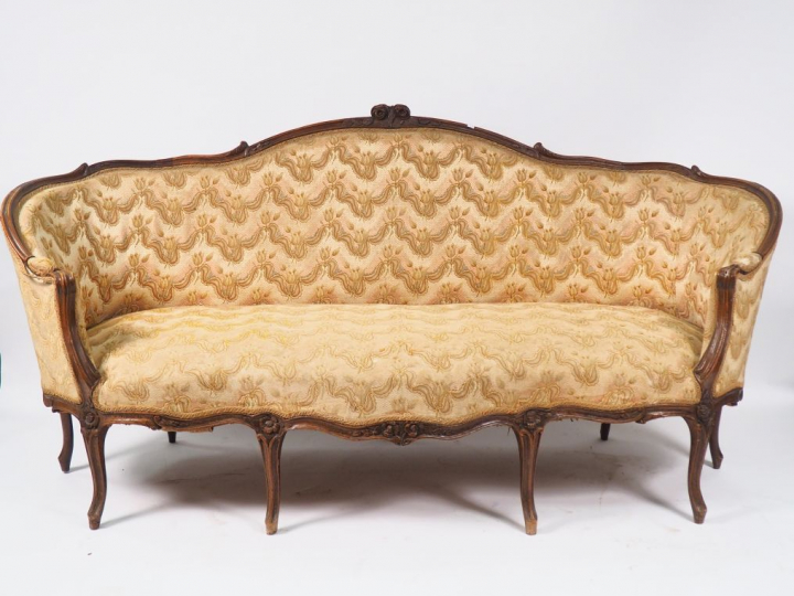 Canapé corbeille Louis XV en noyer mouluré et sculpté, à décor de fleu