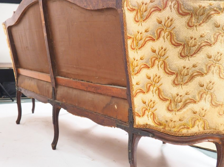 Canapé corbeille Louis XV en noyer mouluré et sculpté, à décor de fleu