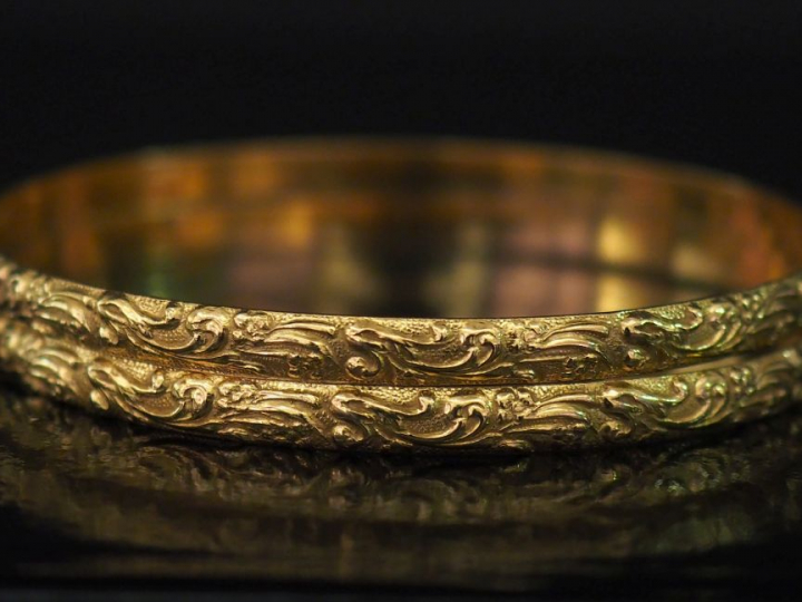 Paire de bracelets joncs en or jaune, à décor de rinceaux feuillagés e