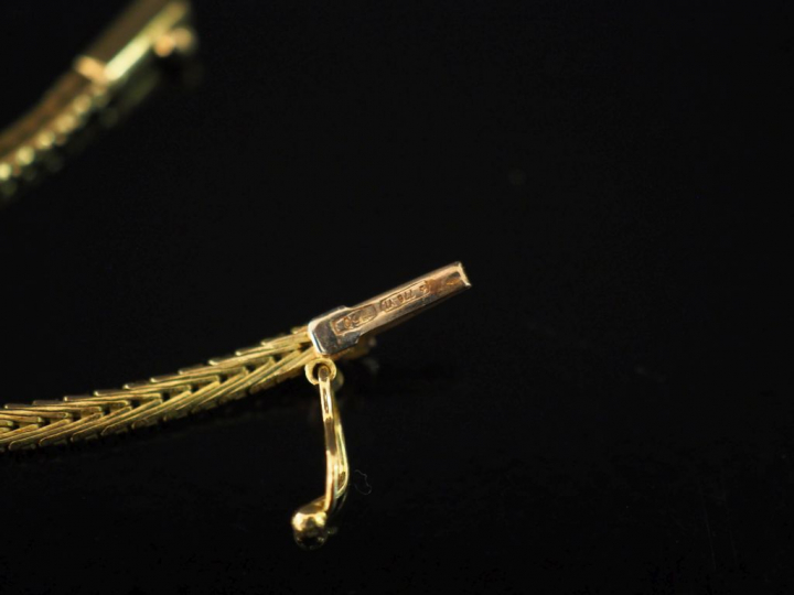 Collier articulé trois tons d'or, maille plate, se terminant en pointe