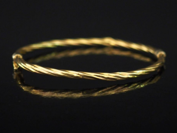 Bracelet jonc de forme ovale en or jaune, à décor de cotes torses.  5 