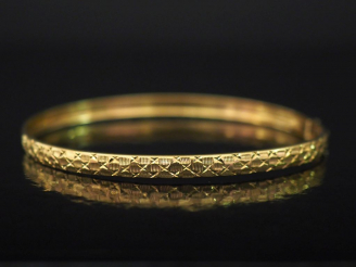 Vente aux enchères Bracelet jonc de forme ovale en or jaune, à décor de motifs géométriqu