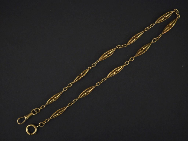 Giletière en or jaune, à décor de maillons ajourés et torsadés. Poids.