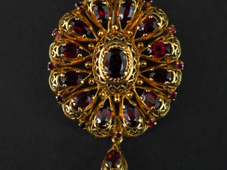 Vente aux enchères Broche en or jaune et grenats en forme de fleur, agrémentée d'une pend