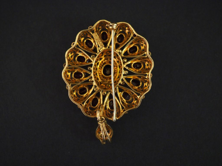 Broche en or jaune et grenats en forme de fleur, agrémentée d'une pend
