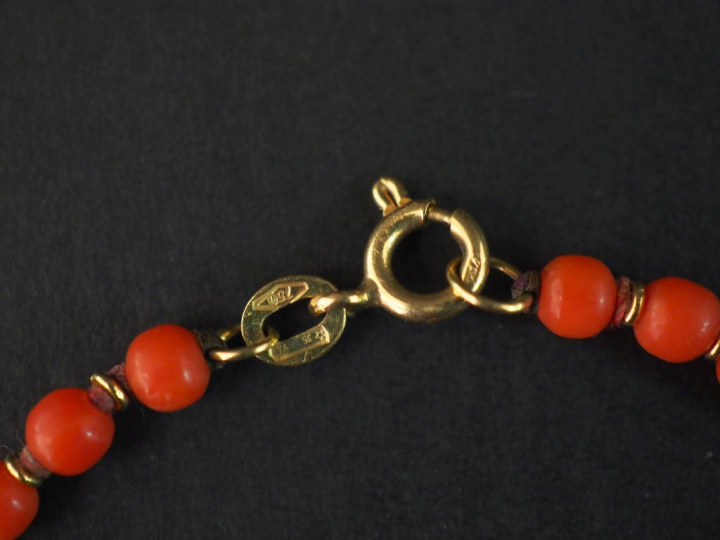 Bracelet en or jaune, orné de perles de corail. Long. 20 cm Poids tel.