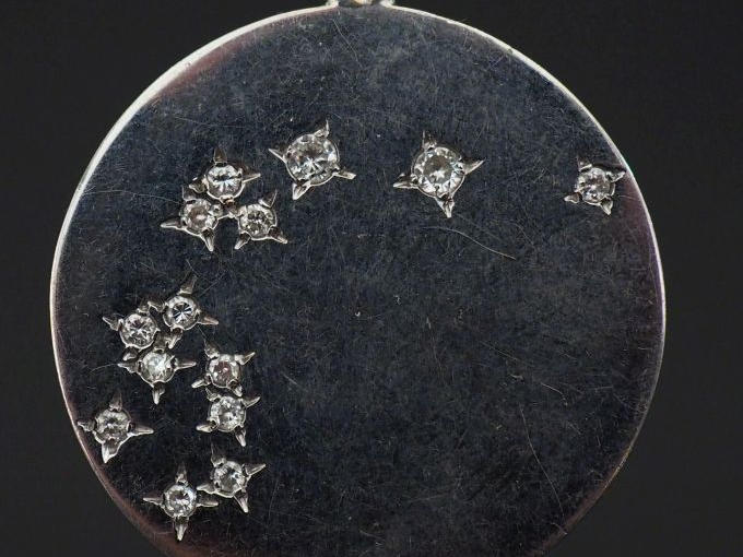 Pendentif circulaire en or blanc, sertie de quatorze petits diamants. 