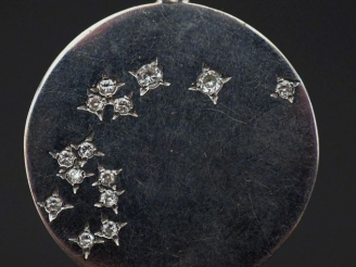 Vente aux enchères Pendentif circulaire en or blanc, sertie de quatorze petits diamants. 