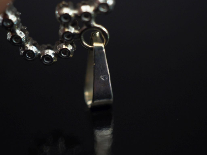 Pendentif en or blanc 750 en forme de cœur, serti de petits diamants. 