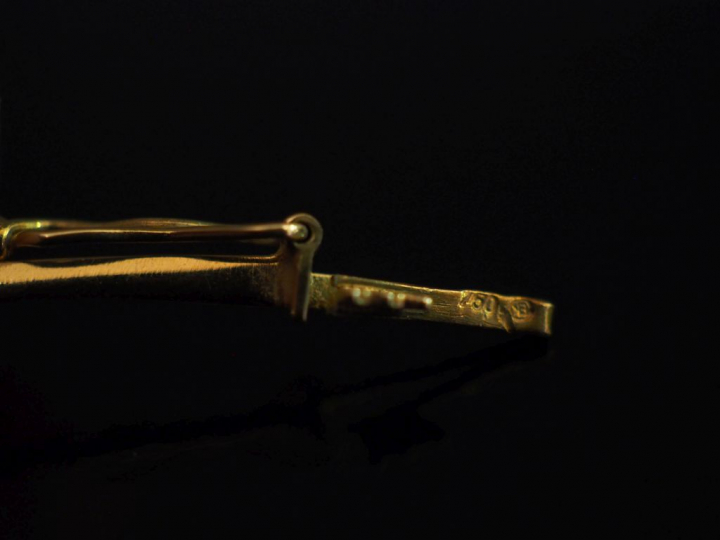 Collier articulé en or jaune, orné en son centre d'un motif composé d'