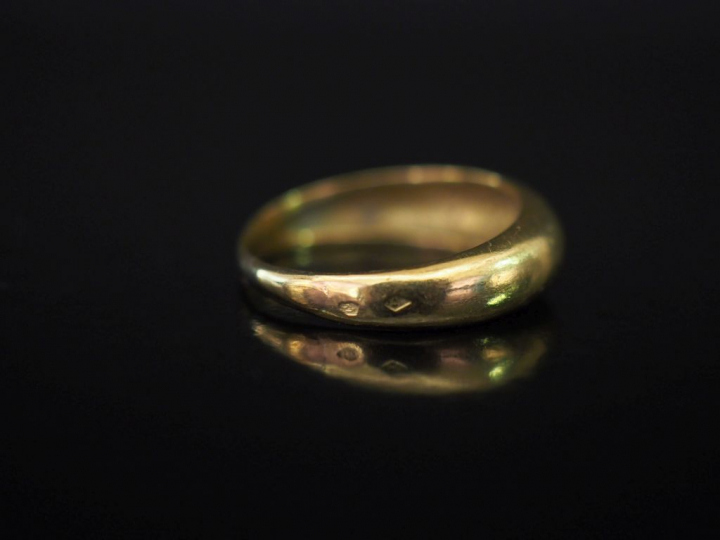 Bague jonc en or jaune, ornée en son centre d'un diamant serti clos de