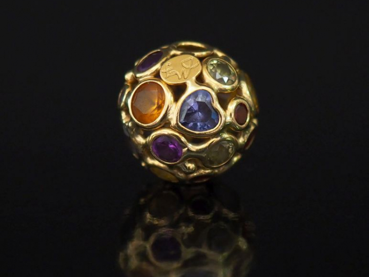 Pendentif rond en or jaune, à décor ajouré et agrémenté de pierres de 