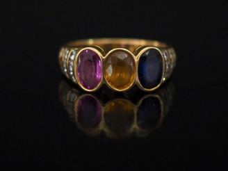 Vente aux enchères Bague jonc en or jaune, sertie en son centre de trois pierres de coule