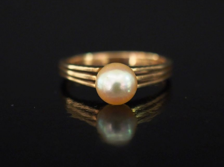 Bague en or jaune, sertie en son centre d'une perle.  Jolie monture aj