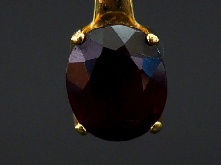 Pendentif en or jaune, serti en son centre d'une pierre rouge. H. 1,8 