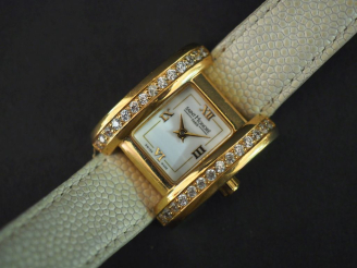 Vente aux enchères SAINT HONORE, Paris Montre bracelet de femme en métal doré et pierres 