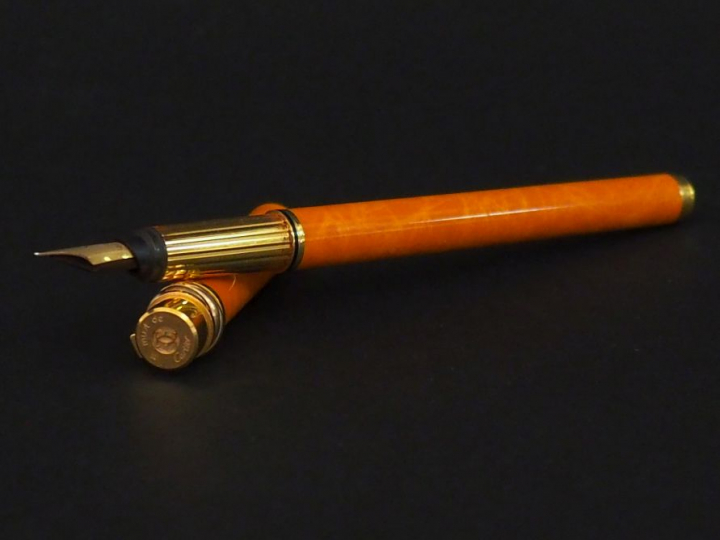 CARTIER, Must Stylo plume en plaqué or et laque orange.  Plume en or j
