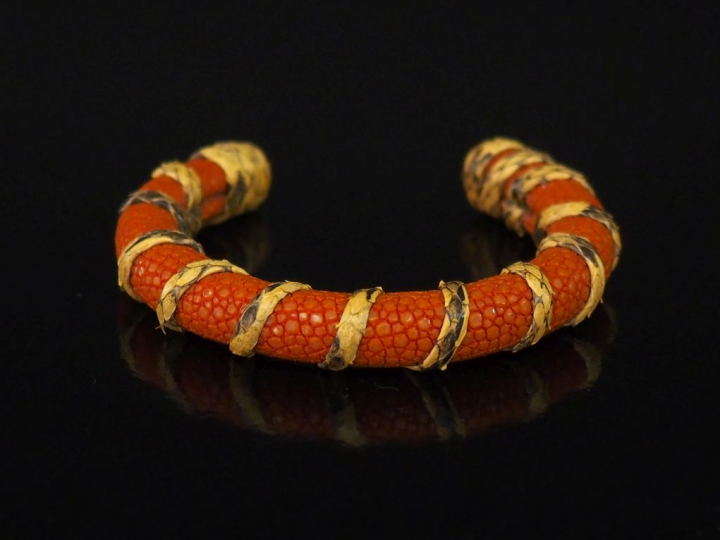 Bracelet jonc en galuchat orange, agrémenté d'un motif d'enroulement. 