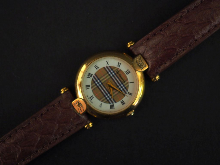 BURBERRYS,  Montre bracelet, boitier en métal doré.  Cadran rond à chi