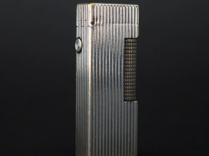 DUNHILL Briquet en métal argenté, à décor de godrons.  H. 6,5 cm Signé