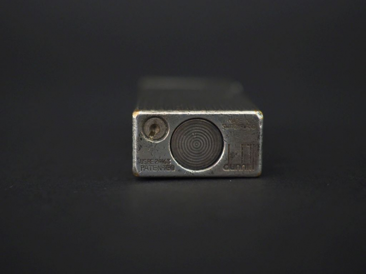 DUNHILL Briquet en métal argenté, à décor de godrons.  H. 6,5 cm Signé