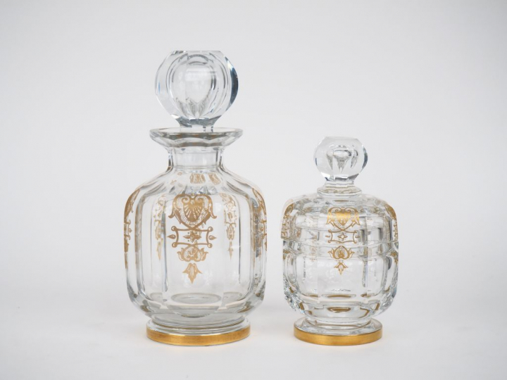 BACCARAT.  2 flacons de toilette en cristal à décor doré. H. 21 cm et 