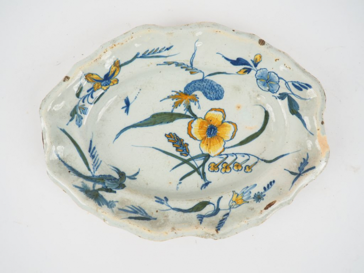 Plat ovale en faience à décor de fleurs polychromes. (égrenures) Dim. 