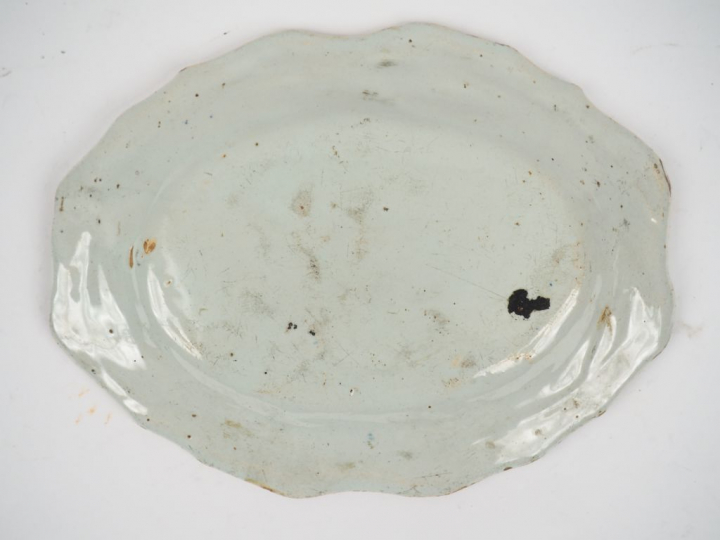 Plat ovale en faience à décor de fleurs polychromes. (égrenures) Dim. 