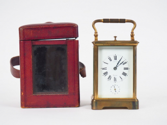 Vente aux enchères Pendulette de voyage en cristal et laiton dans son écrin en cuir borde