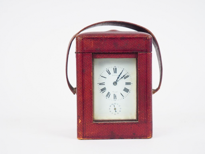 Pendulette de voyage en cristal et laiton dans son écrin en cuir borde