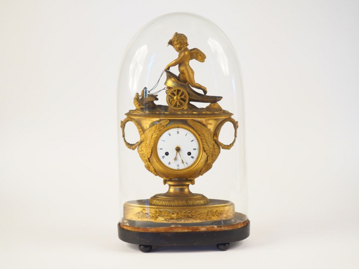 Pendule de cheminée Empire en bronze ciselé et doré "l'amour sur son c