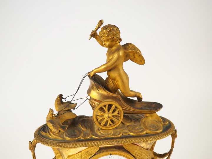 Pendule de cheminée Empire en bronze ciselé et doré "l'amour sur son c