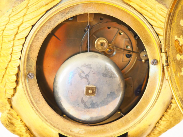 Pendule de cheminée Empire en bronze ciselé et doré "l'amour sur son c