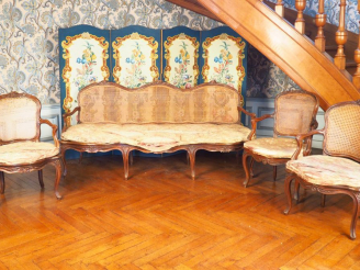 Vente aux enchères Trois fauteuils et un canapé Louis XV canné en noyer mouluré et sculpt