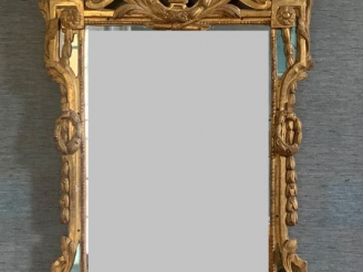 Vente aux enchères Glace Louis XVI à parecloses en bois sculpté et doré, à décor de guirl