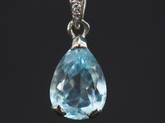 Vente aux enchères Pendentif en or blanc 750, sertie en son centre d'une pierre bleue en 