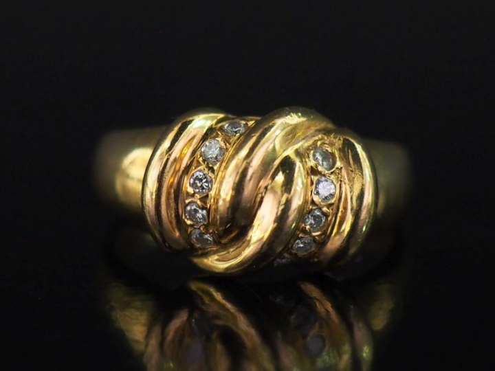 Bague en or jaune 750, à décor en son centre d'un motif de nœud et agr