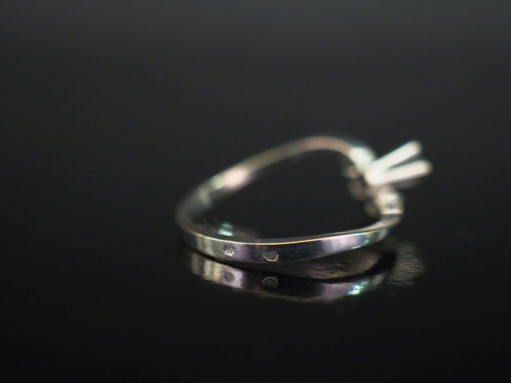 Petite bague de forme stylisée en or blanc 750, sertie de deux émeraud